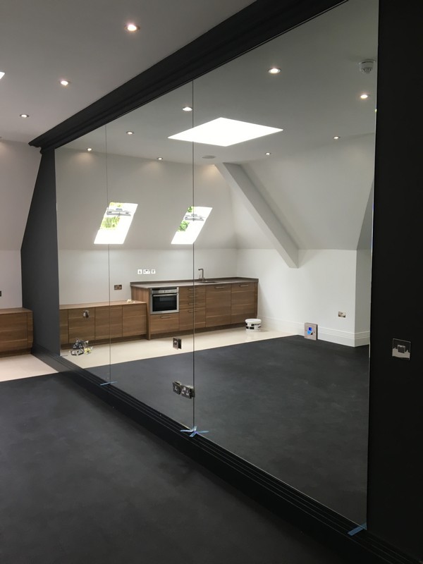 Frameless glass partition in loft conversion by Welwyn Garden City glaziers